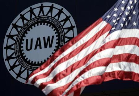 The UAW logo in the background, an American flag in the foreground.